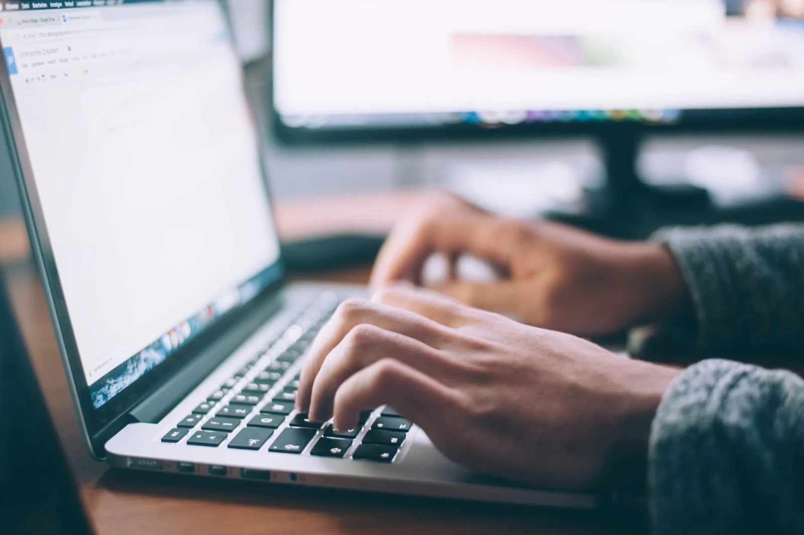 Mains qui tapent sur le clavier d’un ordinateur portable