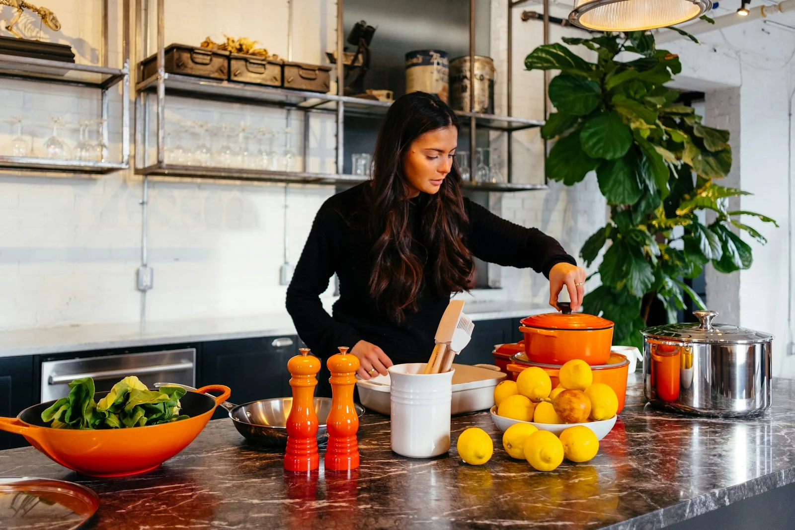 Une femme cuisine dans une cuisine lumineuse, entourée de casseroles et de citrons